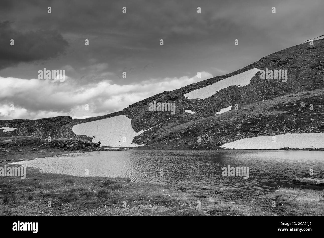 Wanderer erkundet das Ufer der kleinen alpinen Seen Stockfoto