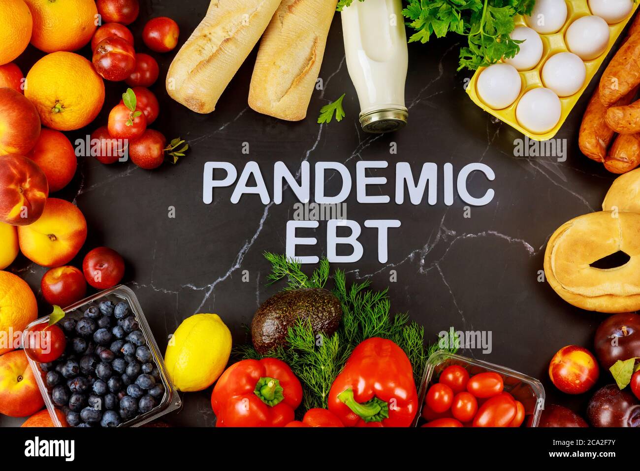 Pandemie-Programm für Nahrungsmittelvorteile. Obst und Gemüse auf schwarzem Hintergrund mit Text. Stockfoto