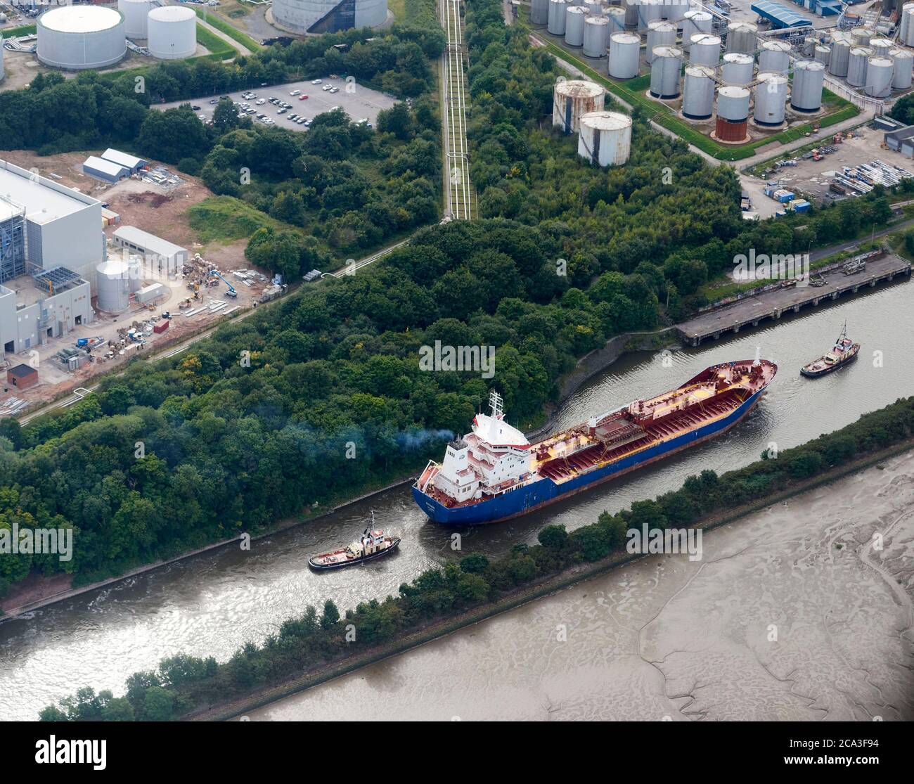 Ein Öltanker, der von zwei Schlepper in den Fluss Mersey geführt wird, in Ellesmere Port, Merseyside, Nordwestengland, Großbritannien Stockfoto