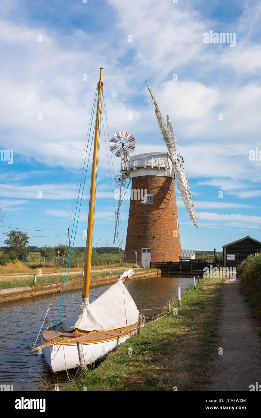 Horsey Windmühle, Blick im Sommer auf Boote, die auf dem Schleppweg bei Horsey im Nordosten der Norfolk Broads, East Anglia, England, UK, festgemacht sind Stockfoto