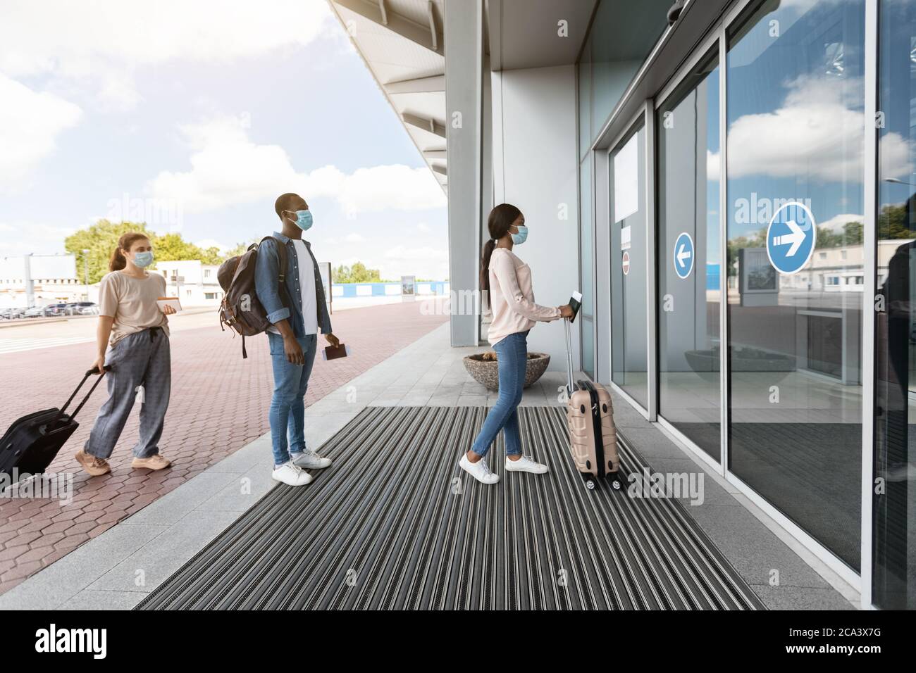 Flughafen Soziale Distanzierung. Passagiere In Masken Stehen In Der Warteschlange, Um Das Terminal Zu Betreten Stockfoto