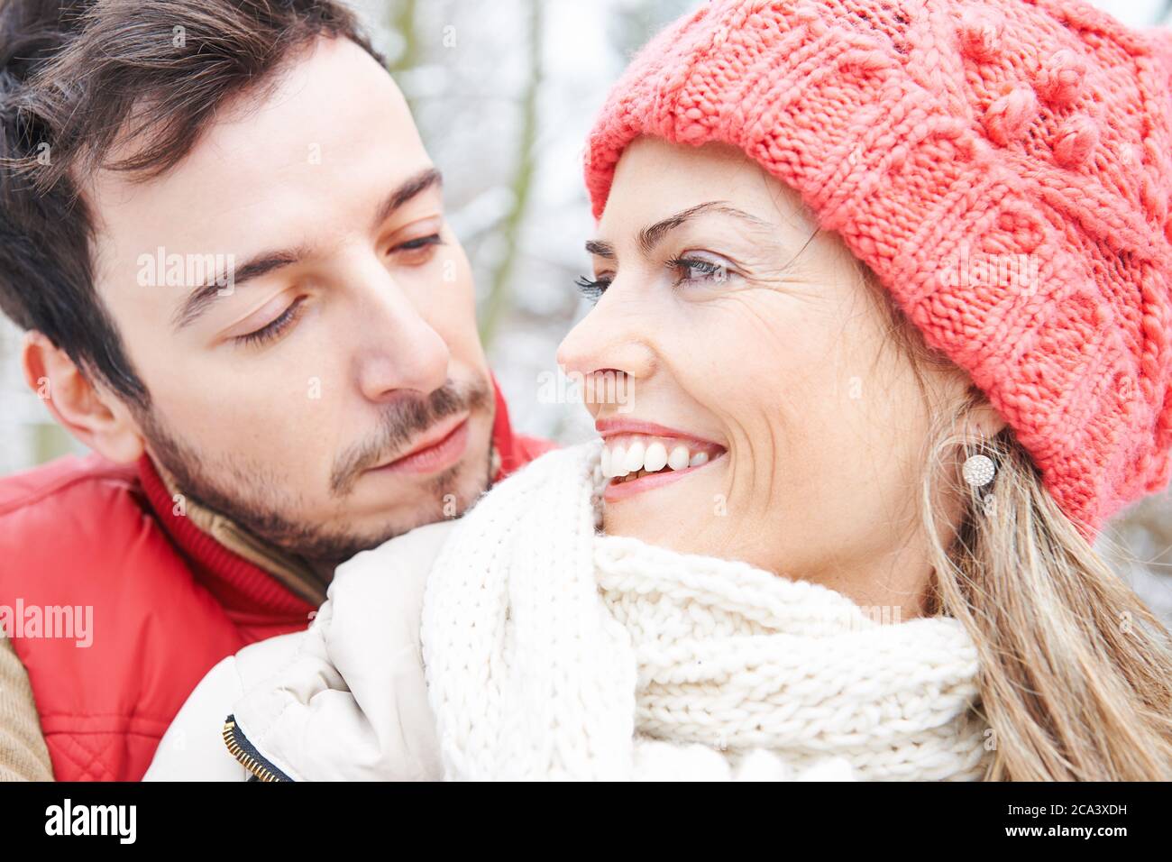 Glückliches Paar kuschelt im Winter gemeinsam im Freien Stockfoto