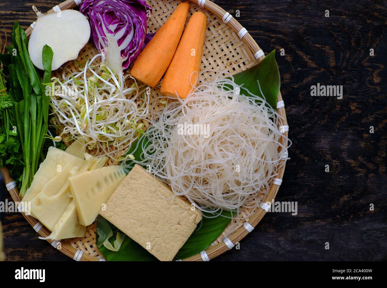 Tablett mit Rohstoffen vegane Nudeln Suppe, buntes Gemüse wie Karotte, Bohnensprossen, Bambus-Shoot, Tofu, einfache vietnamesische Gericht gesund, Ernährung Stockfoto