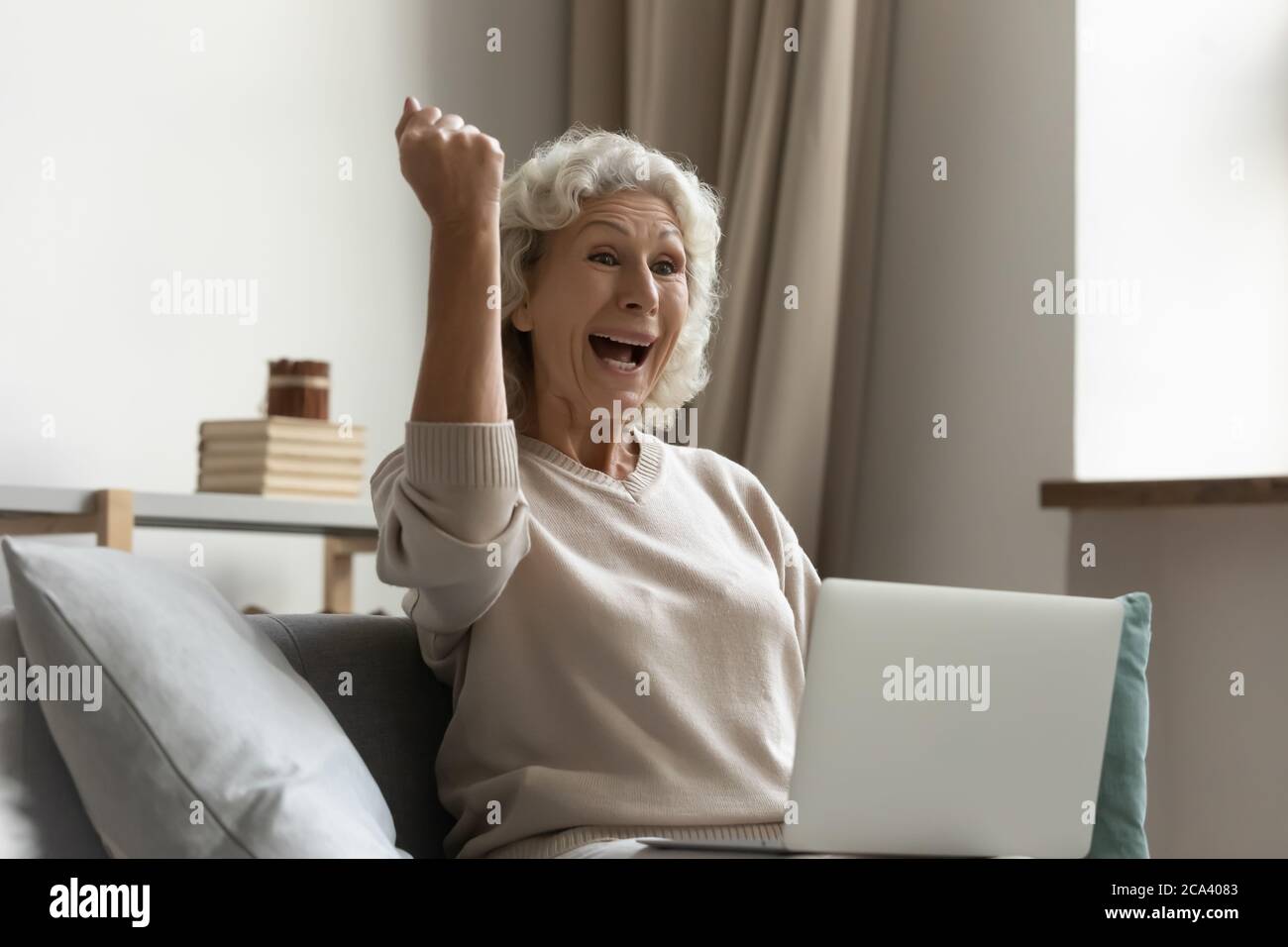 Ältere Frau, die per E-Mail tolle Nachrichten erhält, fühlt sich aufgeregt Stockfoto
