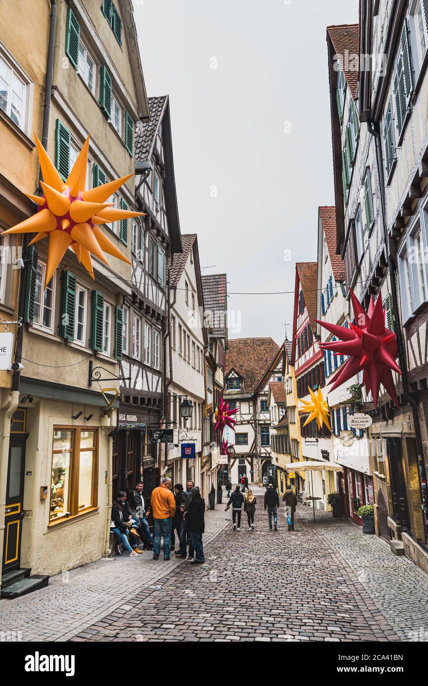 Ruhige Atmosphäre in den mittelalterlichen Kopfsteinpflasterstraßen von Tübingen. Die Menschen wandern zwischen typischen deutschen Fachwerkhäusern mit Schrägdach - Tübingen, Deutschland Stockfoto