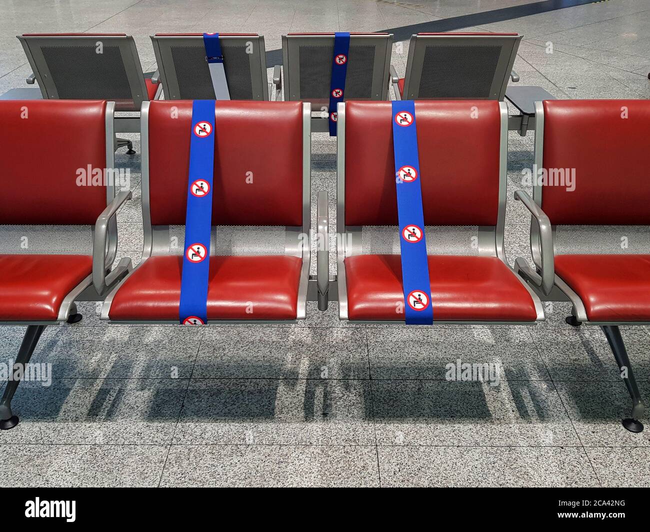 Infolge der COVID-19-Pandemie sind die Sitze am Flughafen begrenzt und voneinander getrennt Stockfoto