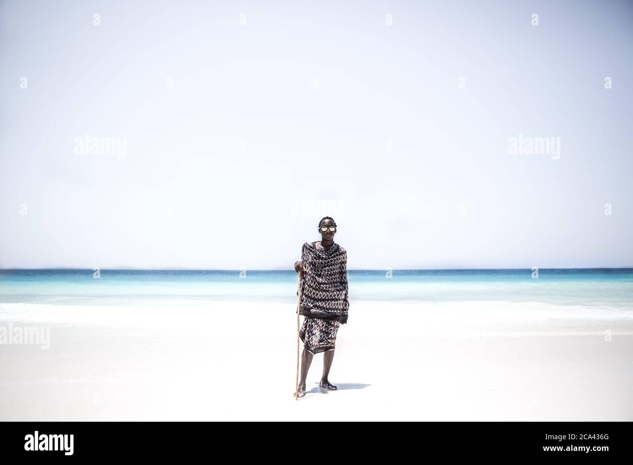 Ein Masai steht am Strand in Sansibar Stockfoto