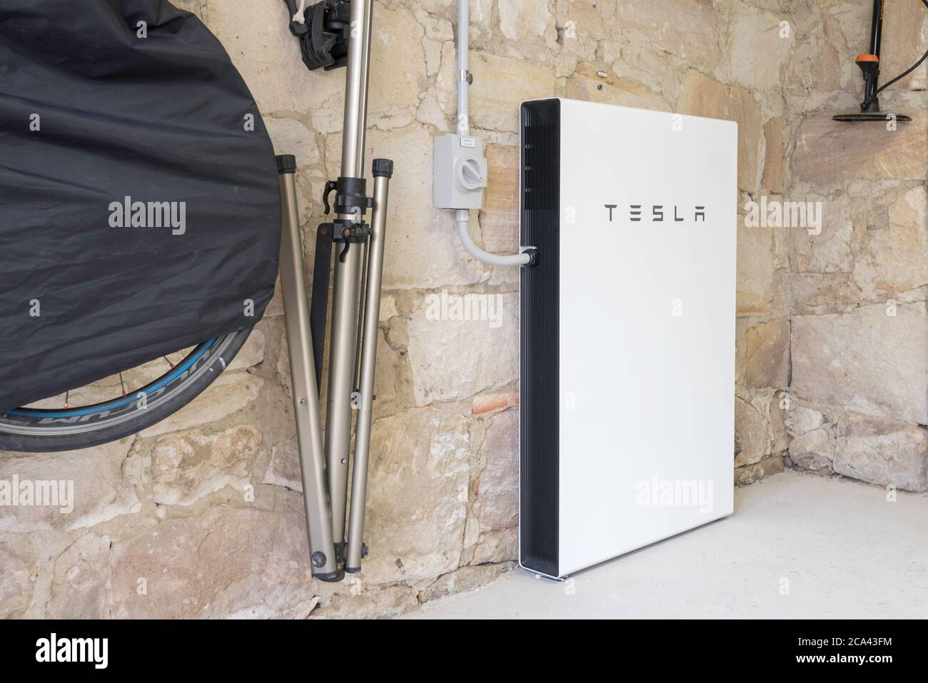 In einer Garage eines Hauses aus den 1920er Jahren mit handgeschnittenen Sandsteinwänden sitzt eine brandneue Tesla Powerwall 2, solarbetriebene Batterie in Sydney, Australien Stockfoto