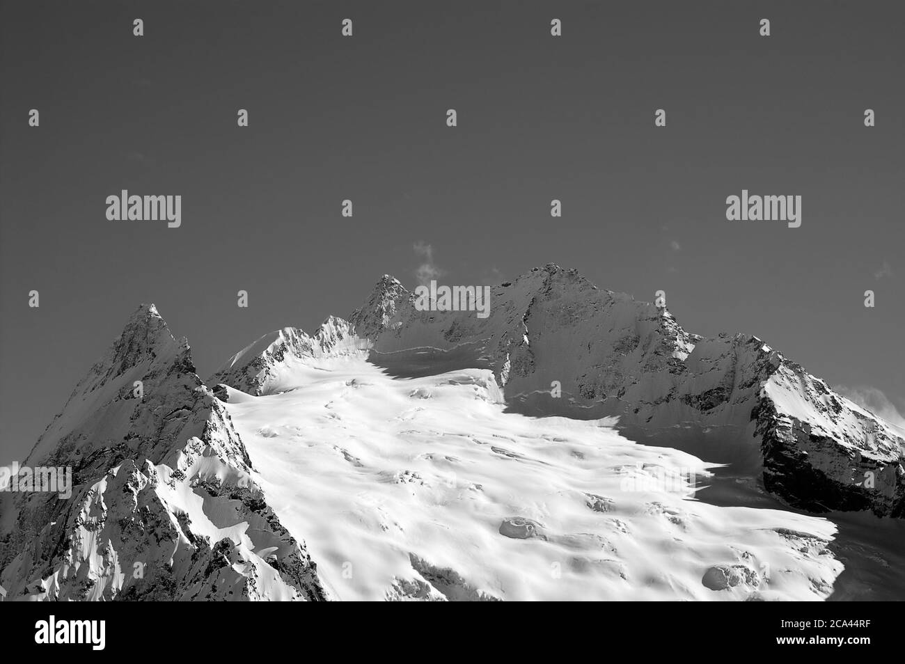 Schwarz-Weiß-Blick von der Skipiste auf schneebedeckten Gletscher und hohe Berggipfel am Winterabend. Kaukasus. Region Dombay. Peak ine montieren. Stockfoto