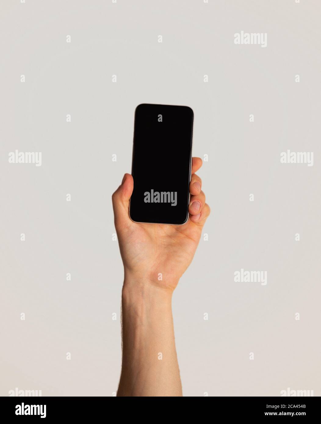 Männliche Hand zeigt Smartphone mit leerem Bildschirm auf hellem Hintergrund, Mockup für mobile App-Design Stockfoto