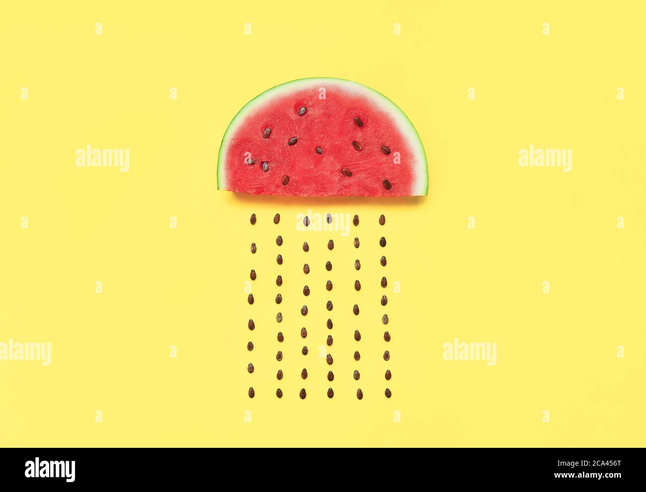 Wassermelonenscheibe mit Samen auf gelbem Hintergrund. Lebensmittelkunst. Flach legen Stockfoto