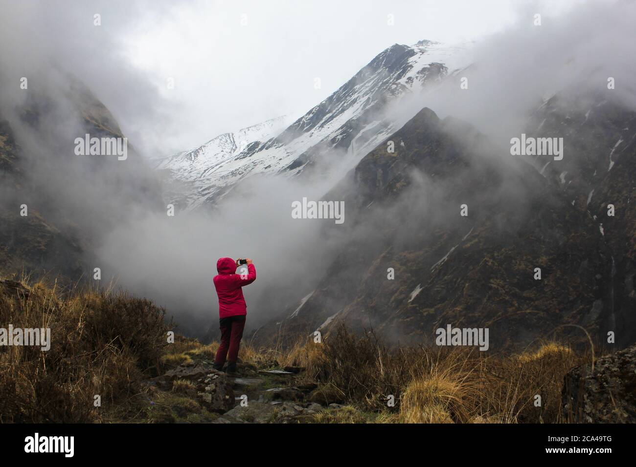 Machapuchare / Nepal - November 2019: Trekker in A Bright macht ein Foto von getrübten und nebligen Machapuchare Pick in Himalaya-Bergen auf ABC Trek Stockfoto