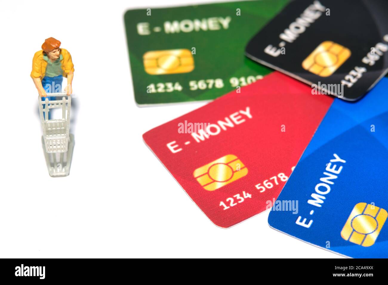 Kontaktlose Zahlung. Frauen gehen einkaufen und zahlen mit elektronischem Geld (E-Geld). Miniatur Menschen Figuren Spielzeug konzeptionelle Fotografie. Stockfoto