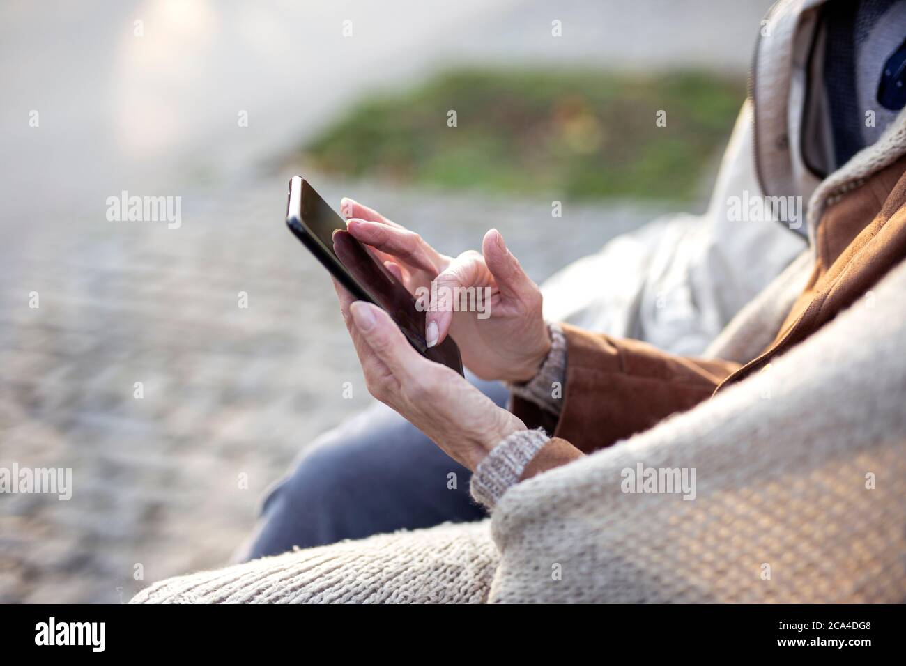 Konzentrieren Sie sich auf ältere Hände mit dem Mobiltelefon Stockfoto