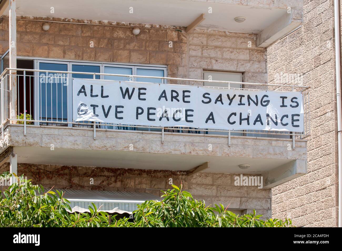 "Alles, was wir sagen, ist dem Frieden eine Chance zu geben" Dieses Schild hängt von einem Balkon vor der offiziellen Residenz des israelischen Präsidenten Reuven 'Ruvi' Ri Stockfoto