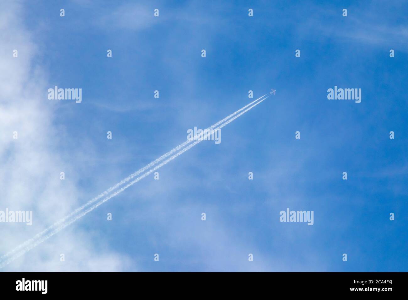 Kondensstreifen eines Flugzeugs im blauen Himmel, Wolken Stockfoto