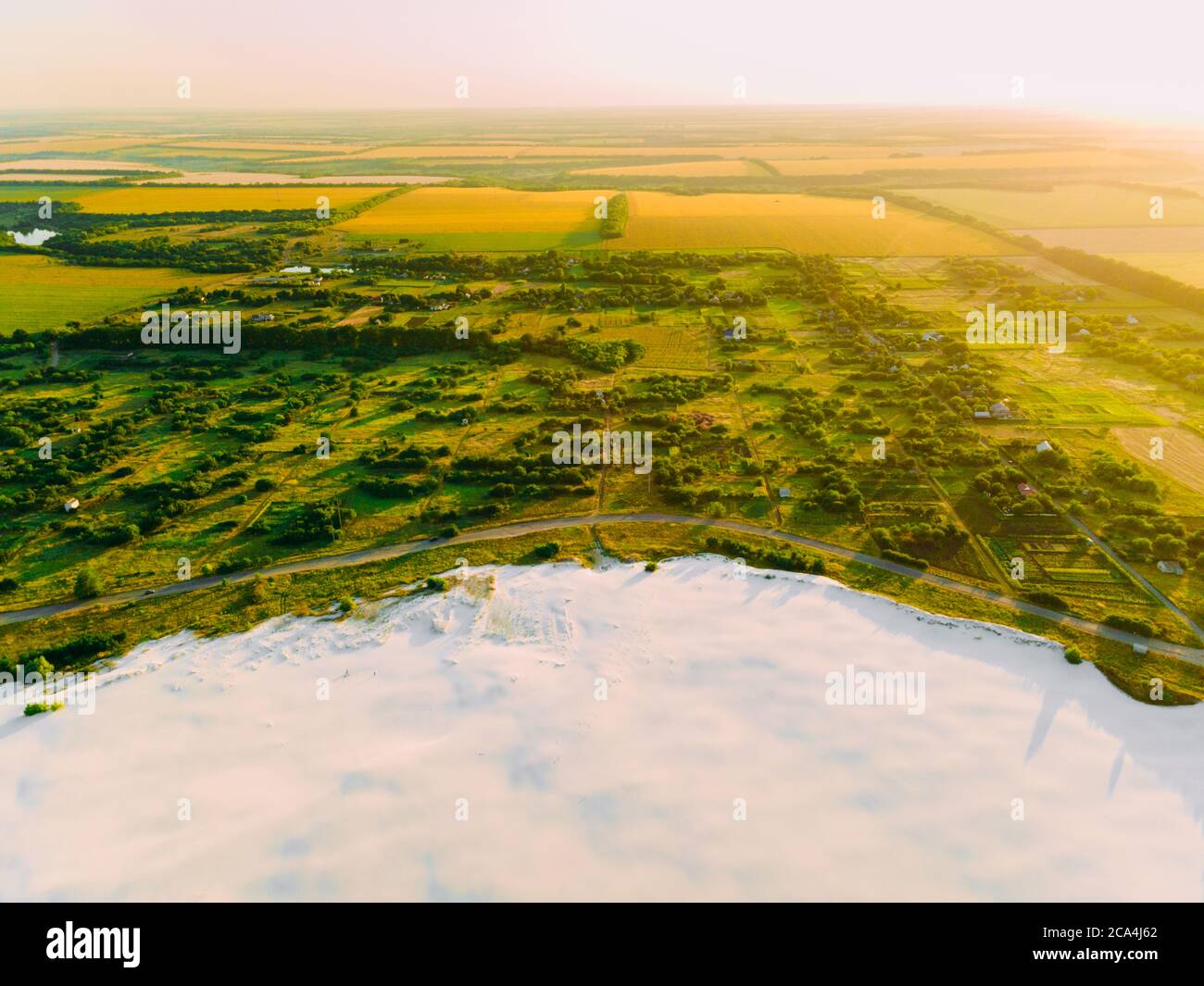 Die Grenze des Wüstengebietes und der grünen Wiese mit dem Fluss ist das Ergebnis der menschlichen zerstörerischen Tätigkeit in der Umwelt. Blick von der Drohne. Stockfoto