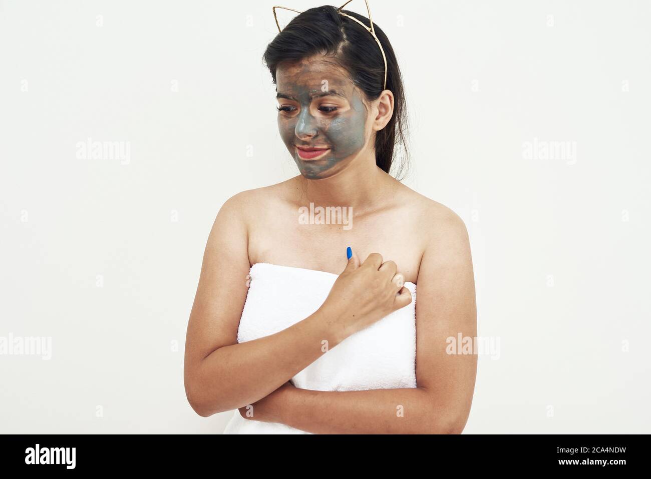 Spa Schönheitsbehandlung, Hautpflege. Junge Frau, die Gesichtsmaske aus grauem Lehm auf ihr Gesicht anwendet. Stockfoto