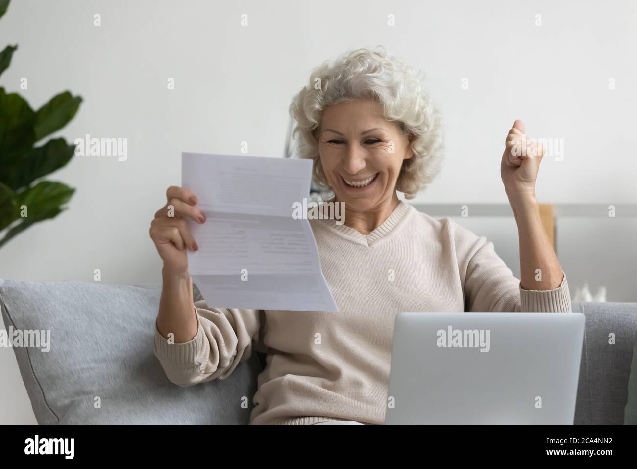Ältere Frau fühlt sich überglücklich lesen große Nachrichten in Brief Stockfoto