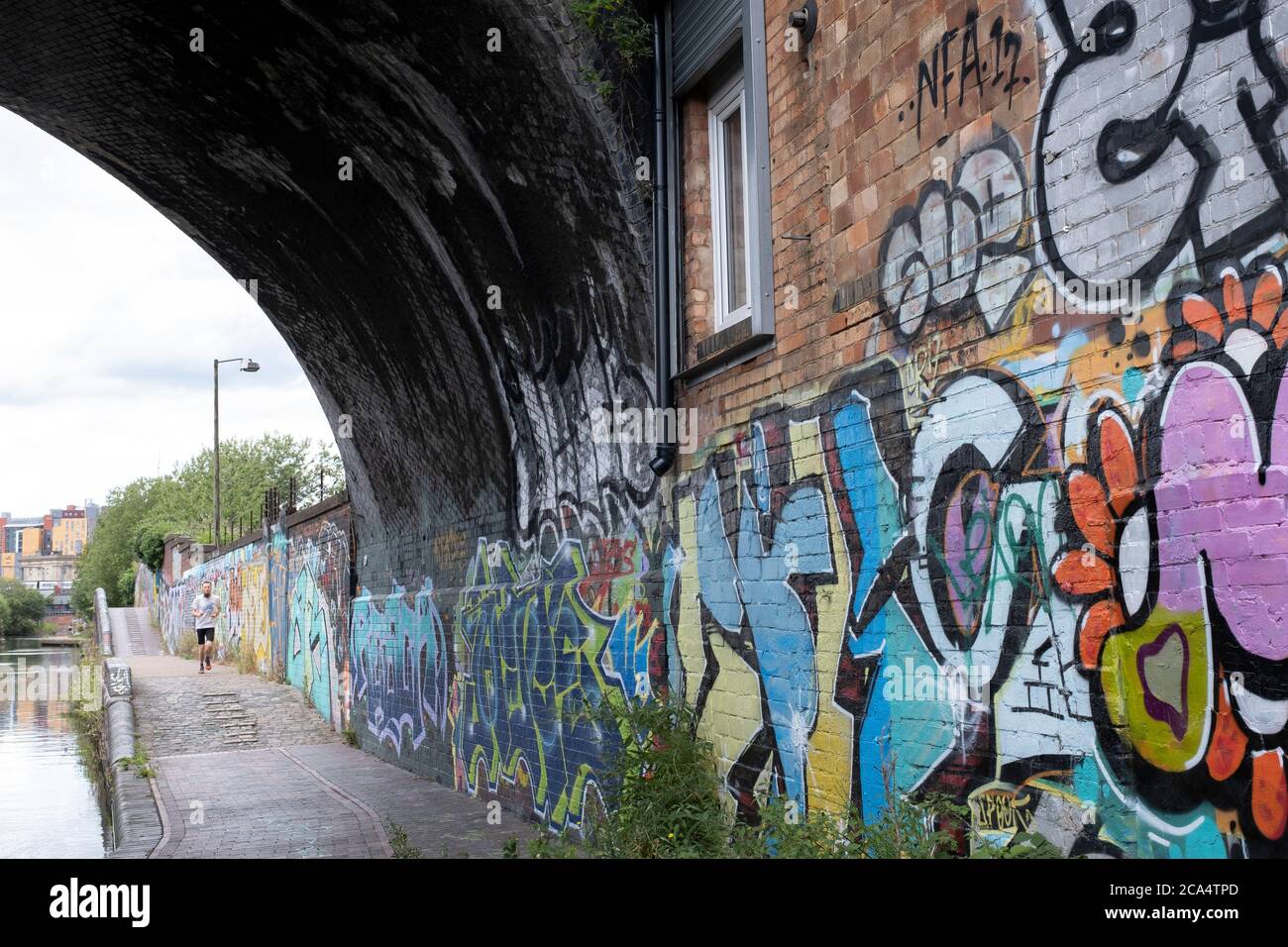 Szene mit Graffiti entlang des Grand Union Canal, ganz in der Nähe des Stadtzentrums am 3. August 2020 in Birmingham, Großbritannien. Birmingham hat rund 35 Meilen von Kanälen, angeblich mehr als in Venedig, und sind sehr viel eine Erinnerung an ein Birminghams Industrieerbe. Während der industriellen Revolution waren diese Kanäle beschäftigt, transportierten schwere Güter wie Kohle, Eisen, während sie eine entscheidende Rolle bei der Entwicklung von Birmingham als industrielles Kraftpaket spielten. Stockfoto