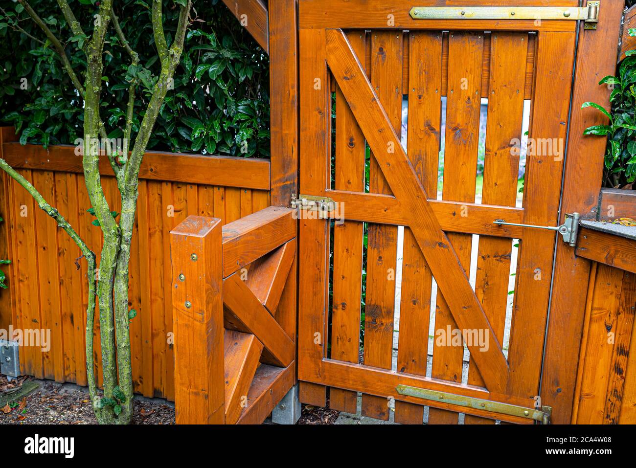 Hölzerne Tor und Zaun auf der Rückseite des Home Garten. Das Tor ist mit einem Vorhängeschloss verschlossen. Stockfoto