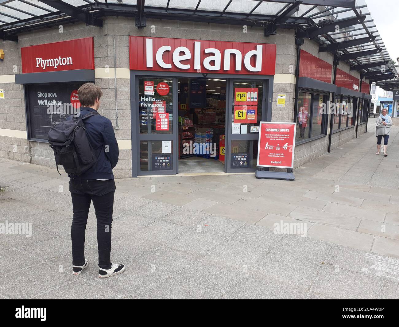 Schlange von Menschen außerhalb zeigen auf Höhe der Beschränkungen warten Zum Kauf von Waren und Einkaufen Covid 19 Coronavirus Soziale Distanzierung Stockfoto