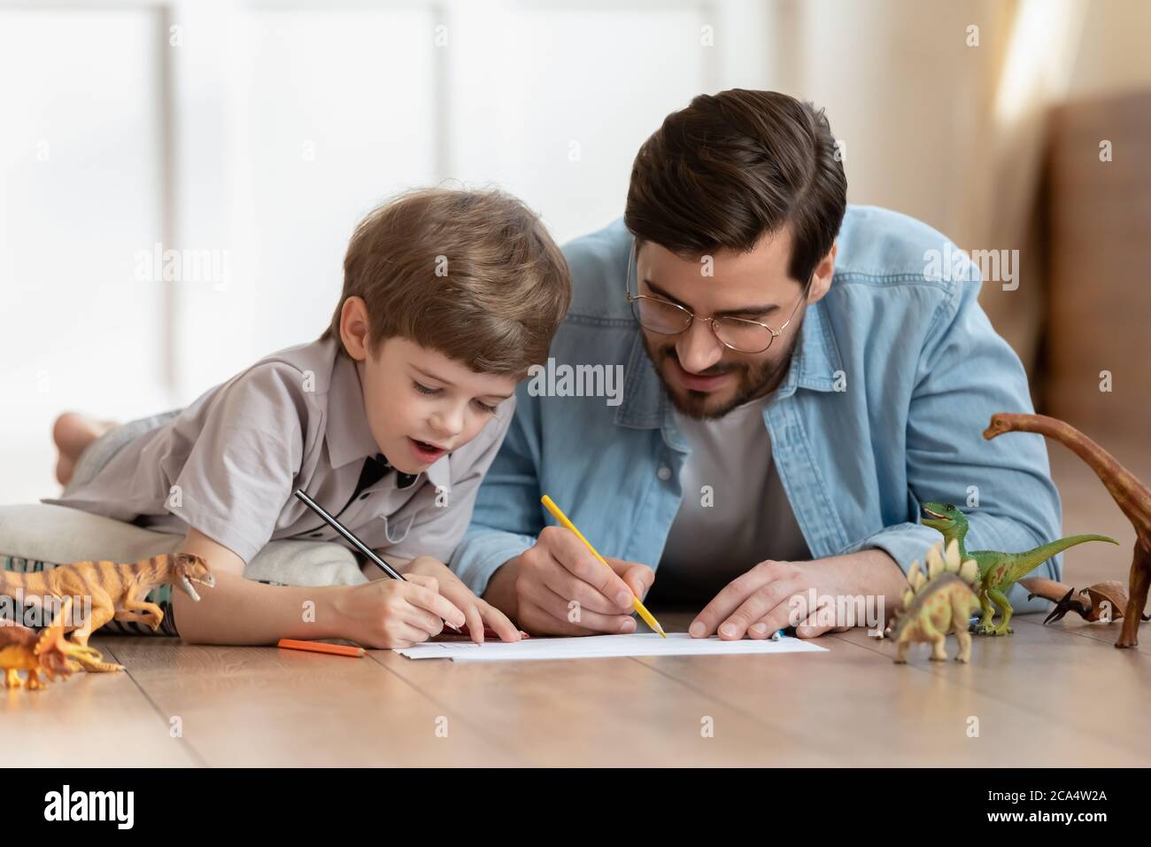 Glückliches kleines Kind Junge Zeichnung Bilder mit Vater. Stockfoto