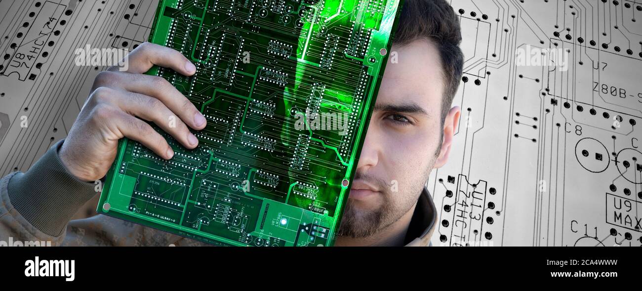 Computerprogrammierer, der eine Leiterplatte hält Stockfoto