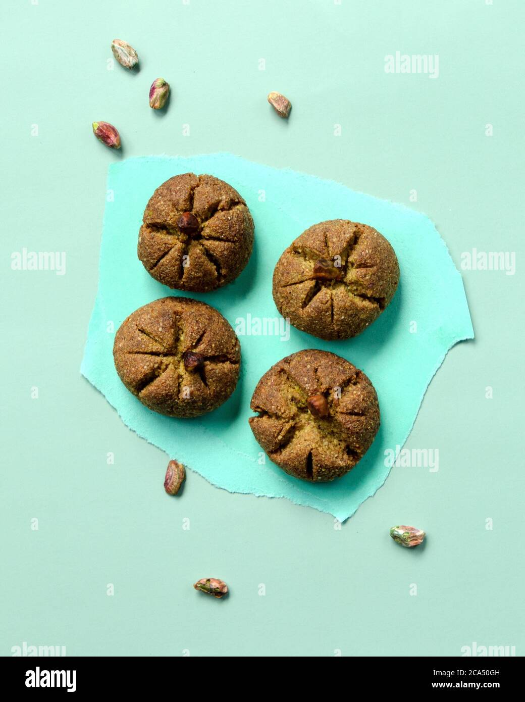 Traditionelle hausgemachte marokkanische festliche Ghoriba Cookies mit Pistazien Nüsse auf trendigen minzfarbenen Hintergrund. Stockfoto