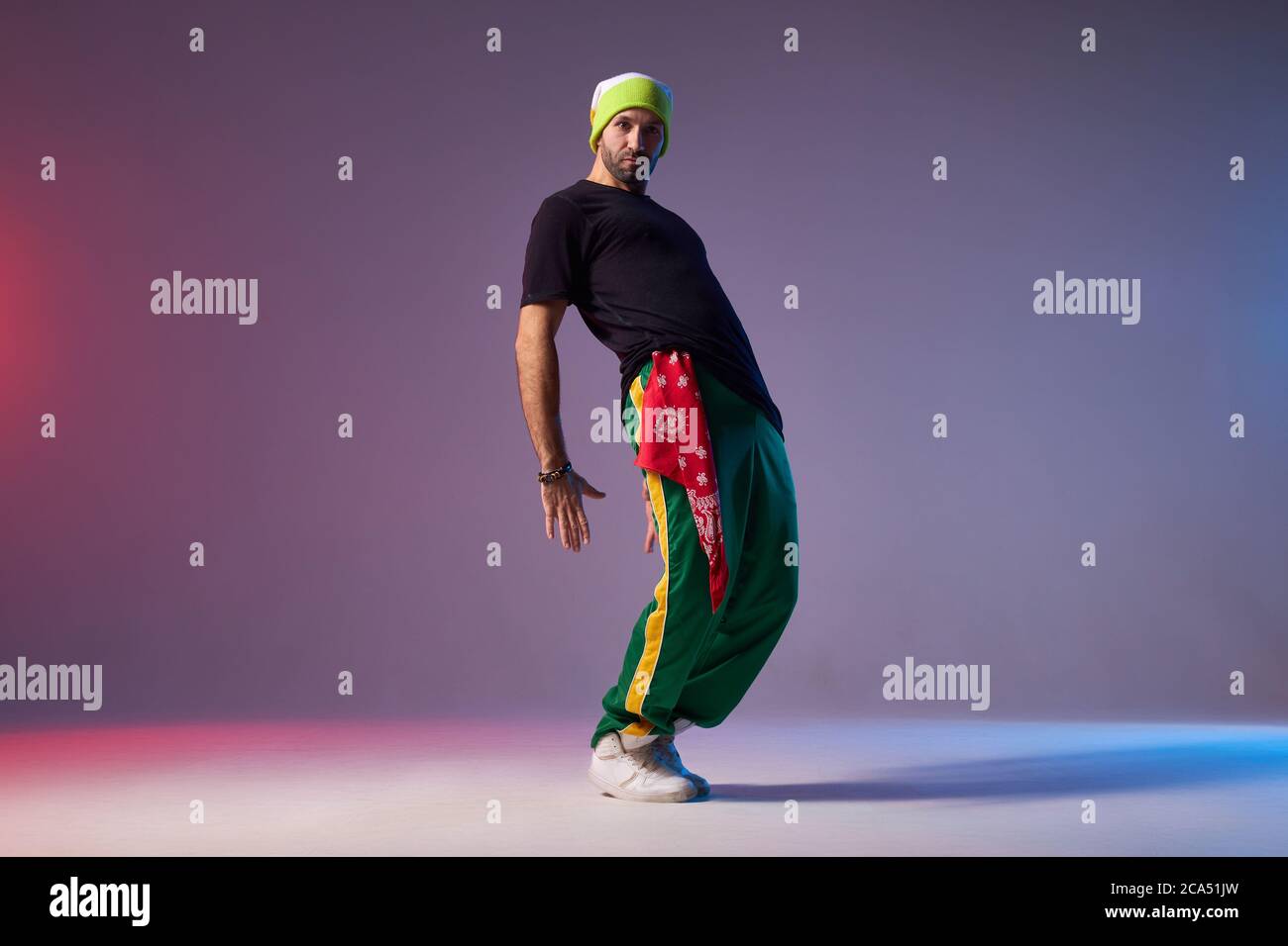 Junge aktive Mann in Sportkleidung gekleidet, Durchführung Hip-Hop-Stil Tanz, Training im Tanzstudio, sich zurückbeugen, Emotionen ausdrücken, Blick auf die Kamera Stockfoto