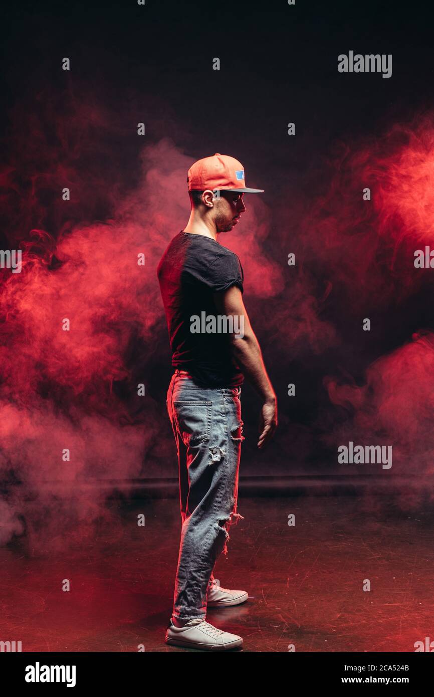 Schöner Mann, der isoliert auf rauchigem Hintergrund tanzt, Freizeitkleidung trägt, Straßentanz Stockfoto