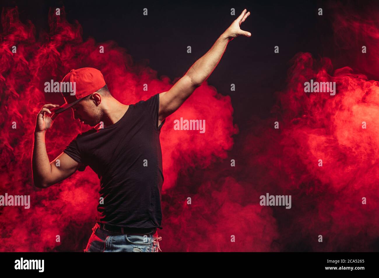 Schöner Mann, der isoliert auf rauchigem Hintergrund tanzt, Freizeitkleidung trägt, Straßentanz Stockfoto