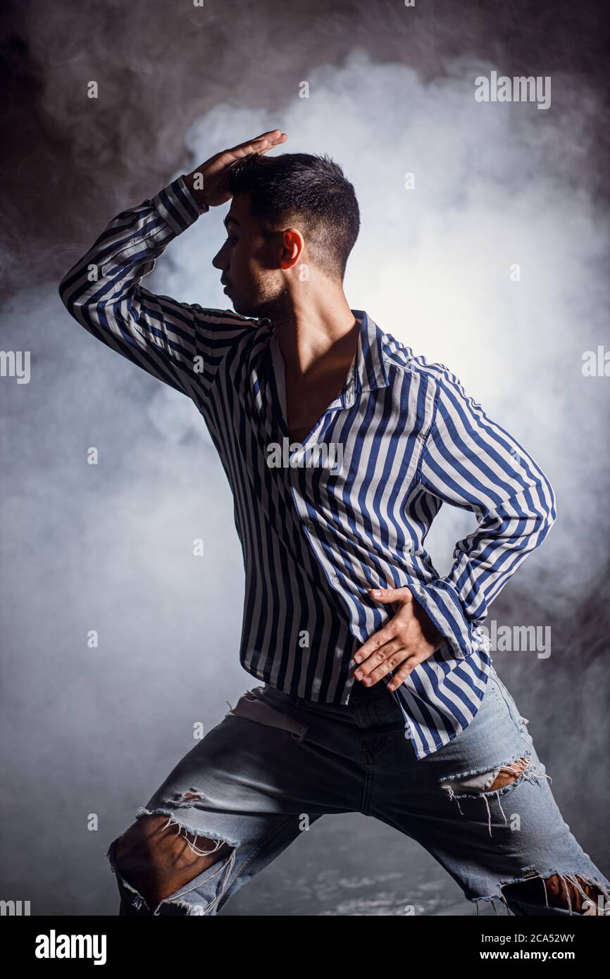 Schöner Mann, der isoliert auf rauchigem Hintergrund tanzt, Freizeitkleidung trägt, Straßentanz Stockfoto