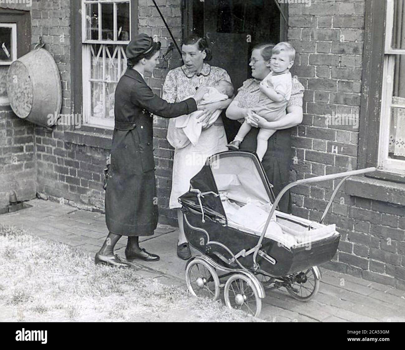 ENGLISCH MIFWIFE Besuch einer Familie in den 1950er Jahren Stockfoto