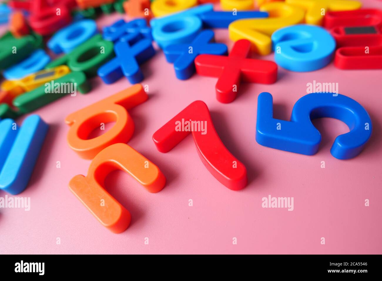 Bunte Plastikbuchstaben auf rosa Hintergrund, Nahaufnahme Stockfoto