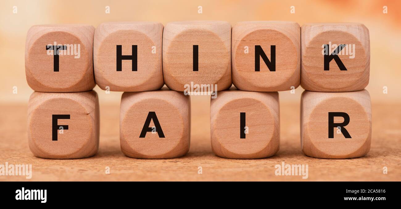 Think fair gedruckt auf Holzwürfel Stockfoto