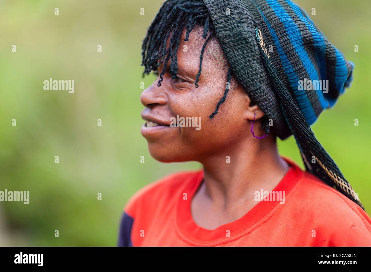 Indonesien, Papua, Baliem-Tal, in der Nähe von Wamena, Yali-Territorium, Dorf Angguruk, Profilansicht einer lächelnden jungen Frau mit Zöpfen Stockfoto
