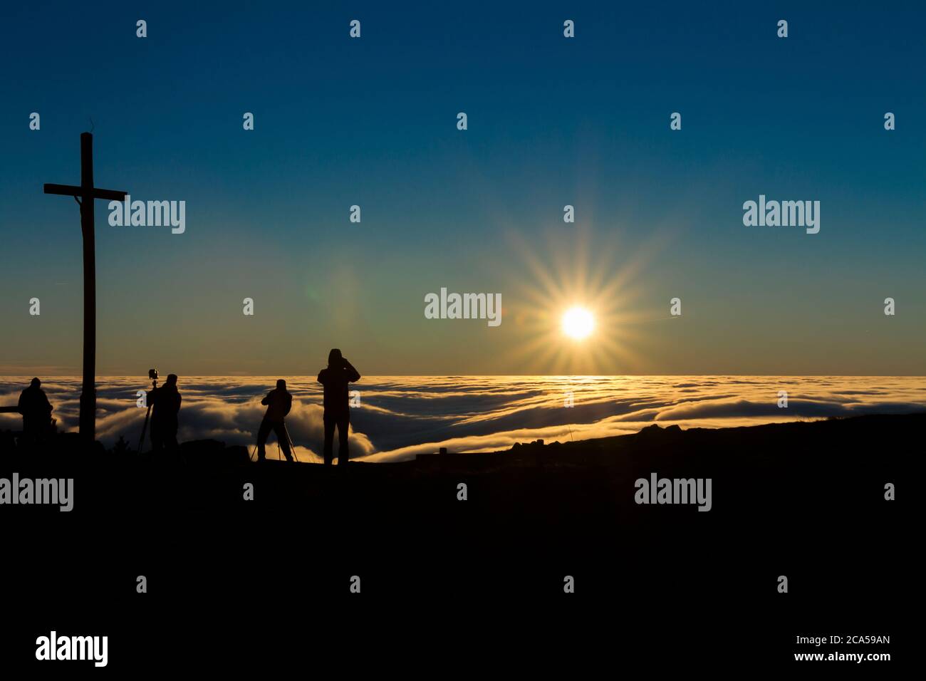 Sonnenaufgang und Inversion am Jested Berg in der Nähe der Stadt Liberec, Tschechien, Schnee und Winter und Blick auf die Seilbahn, Fotografen am Kreuz. Stockfoto