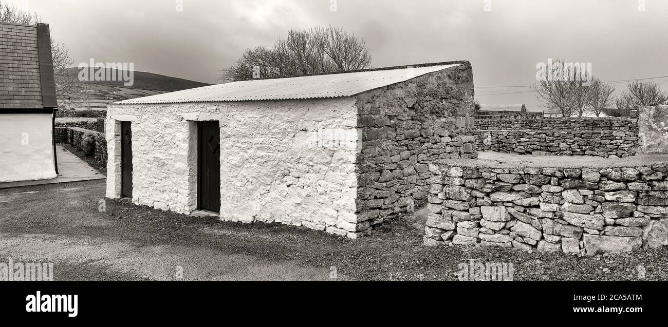Farmgebäude aus schwarzem und weißem Stein, Burren, County Clare, Irland Stockfoto