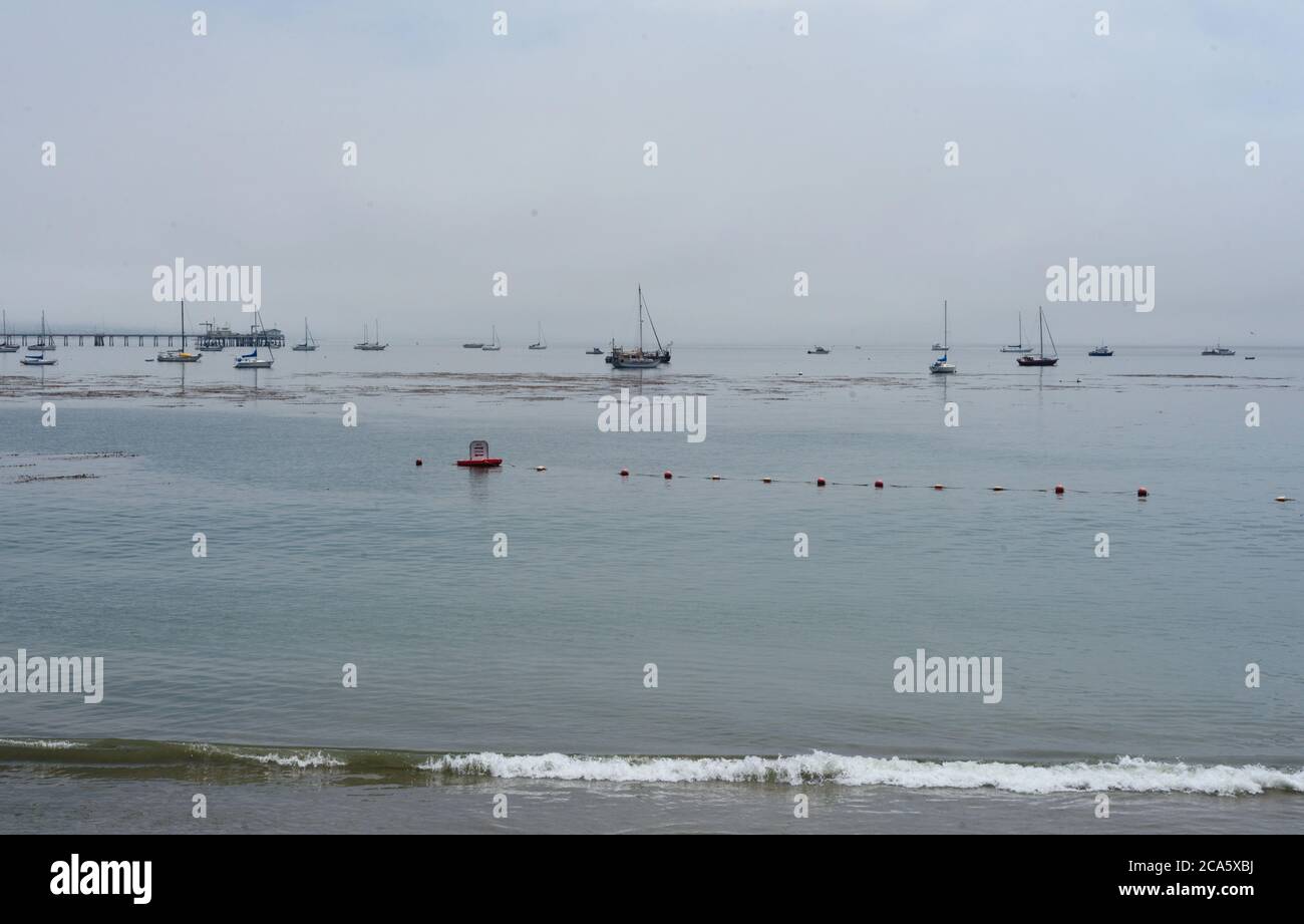 AVAIL Strand im Morgennebel, mit schwachen Booten in der Ferne-der Pazifik Seestrube Gefühl von Geheimnis oder Intrigen, Abenteuer, Exploration. Stockfoto