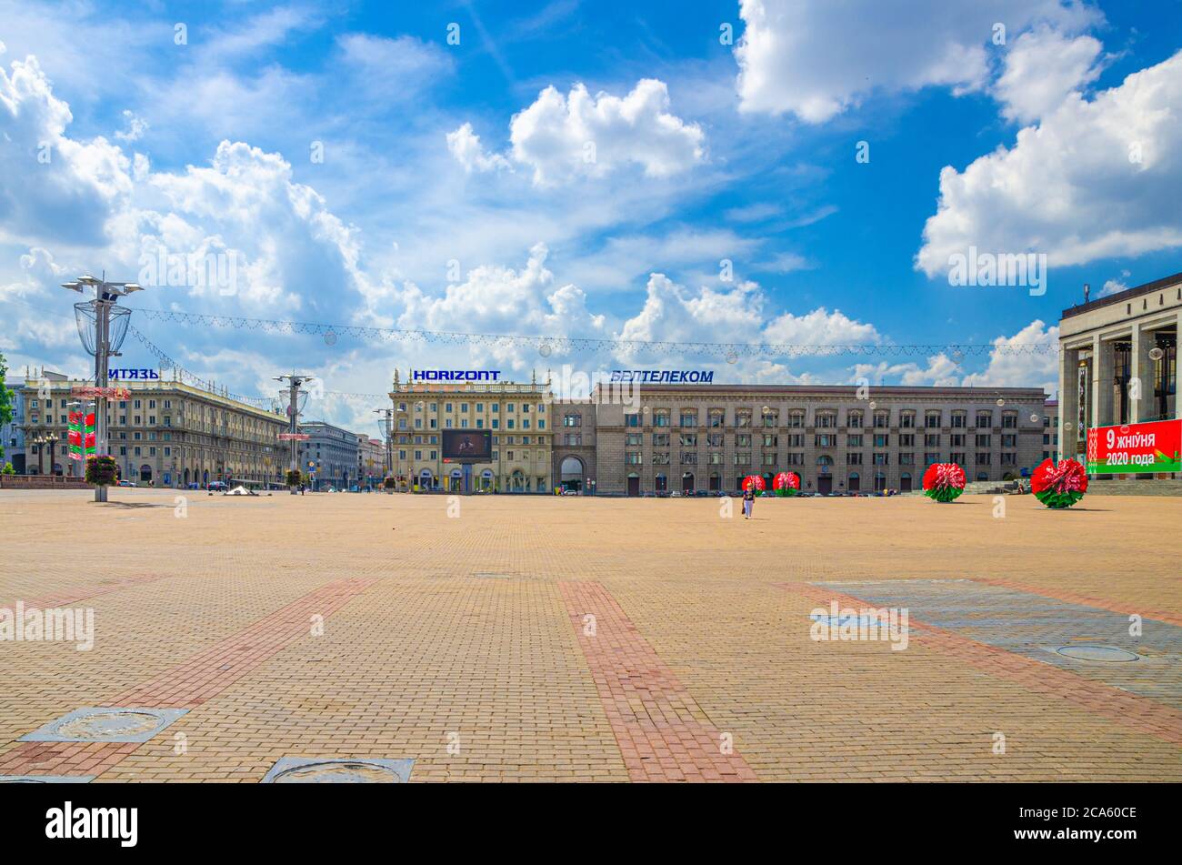 Minsk, Weißrussland, 26. Juli 2020: Oktoberplatz mit sozialistischem Klassizismus Gebäude im Stil des Stalinreiches, blauer Himmel weiße Wolken am sonnigen Sommertag Stockfoto