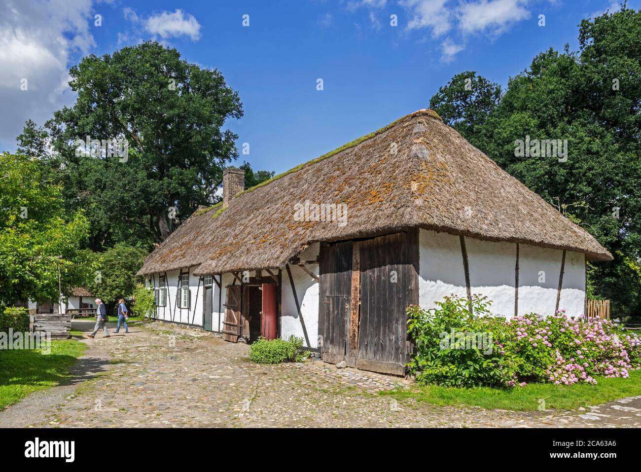 Touristen besuchen 18. Jahrhundert Bauernhof Kilbershoeve mit Strohdach im Freilichtmuseum Bokrijk, Limburg, Flandern, Belgien Stockfoto