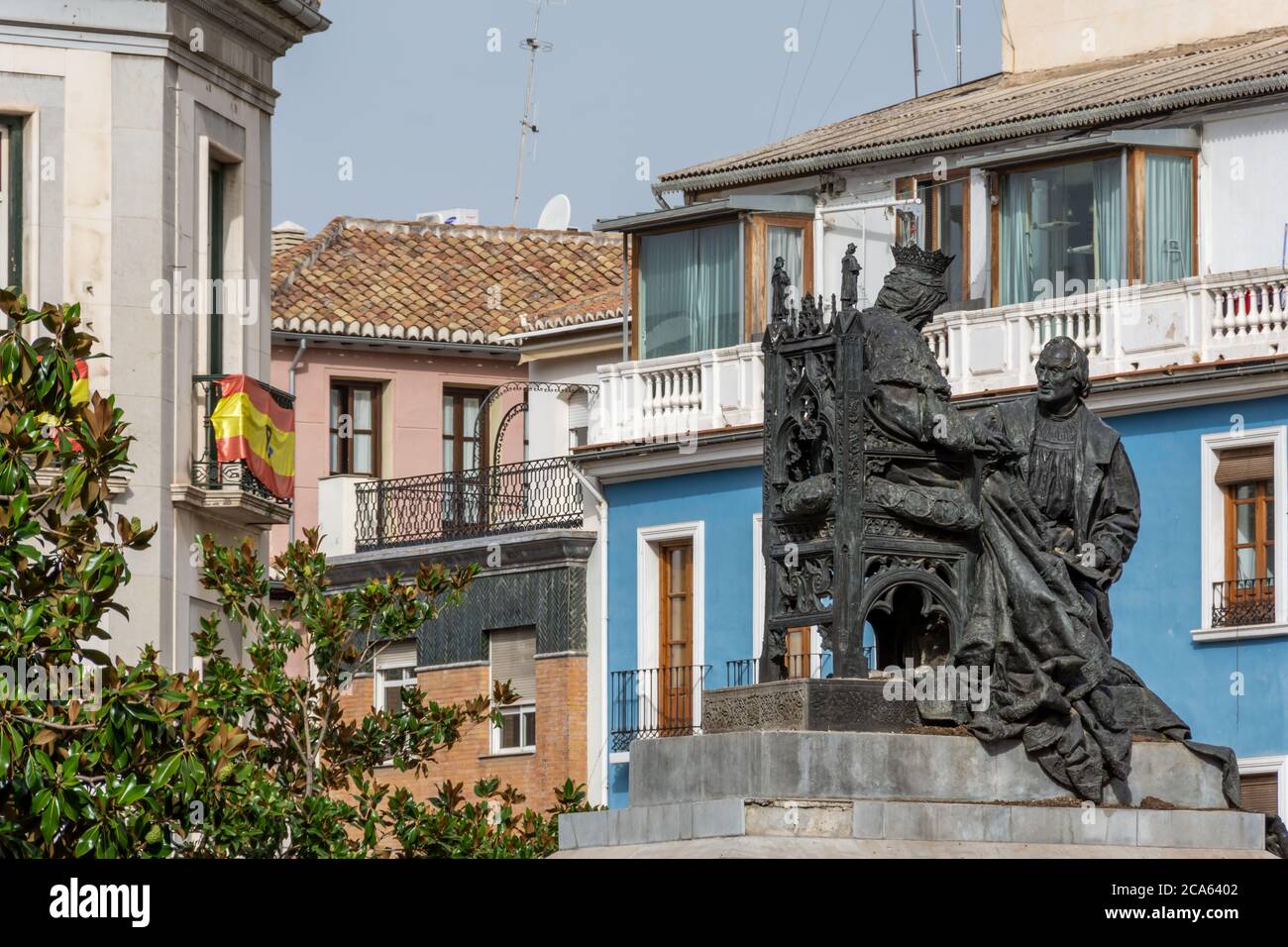 Denkmal von Elisabeth dem Katholischen und Christoph Kolumbus in Granada mit einem blauen Gebäude im Hintergrund Stockfoto