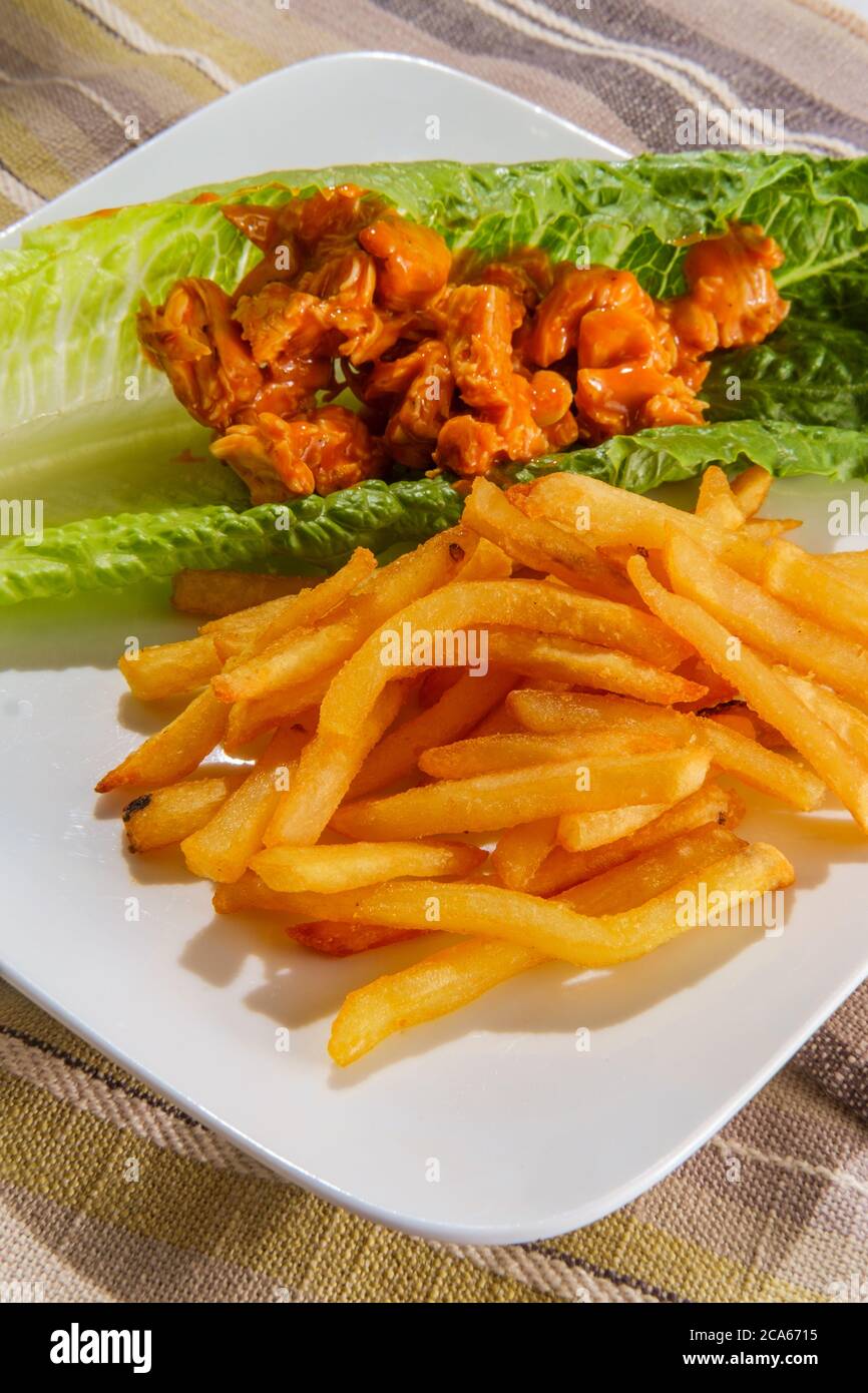 Glutenfreie Büffelbüffel-Hähnchensalat-Sandwich-Wrap mit knusprigen pommes frites Stockfoto