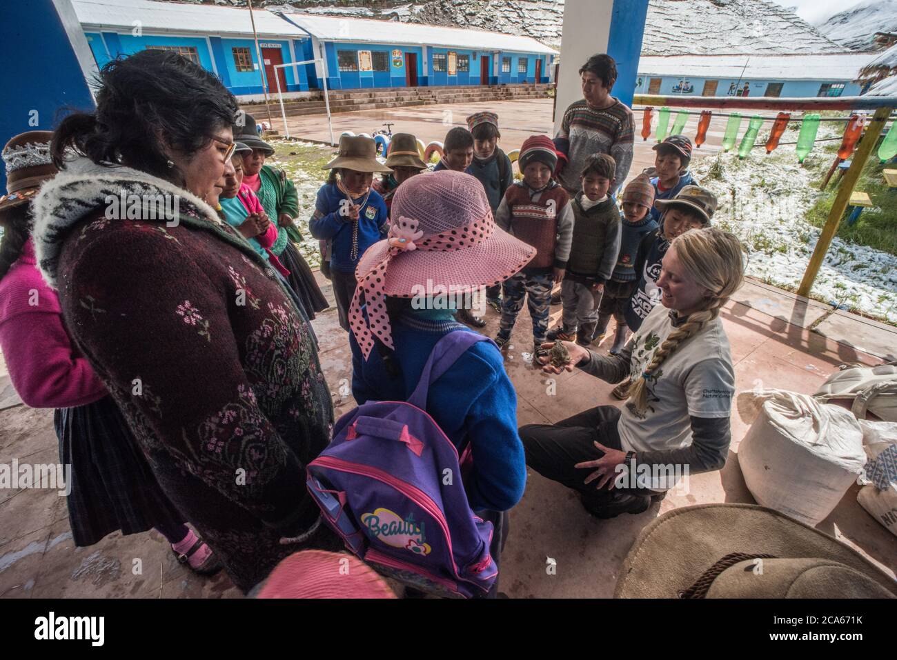 Quechua Kinder und Lehrer versammeln sich um einen Wissenschaftler, der pädagogische Öffentlichkeitsarbeit über Amphibien in Peru macht. Stockfoto