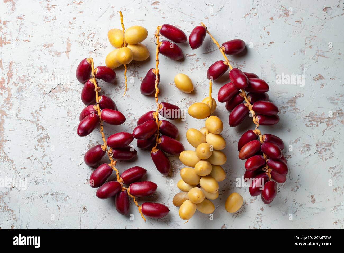 Rote und gelbe frische Datteln Obst auf weißem Hintergrund Stockfoto