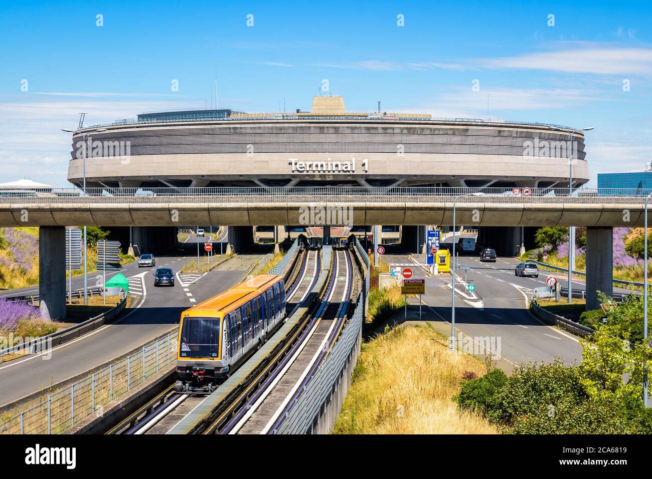 An einem sonnigen Tag verlässt ein CDGVAL-Flughafenshuttle das kreisförmige Betongebäude des Flughafens Paris-Charles de Gaulle am Terminal 1. Stockfoto