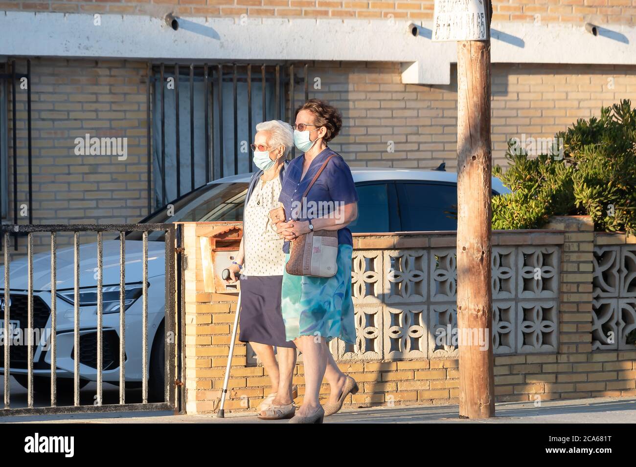 Punta Umbria, Huelva, Spanien - 2. August 2020: Zwei ältere Frauen, die auf der Straße mit Schutzmaske wegen covid-19. Neue Normalität in Spanien Stockfoto