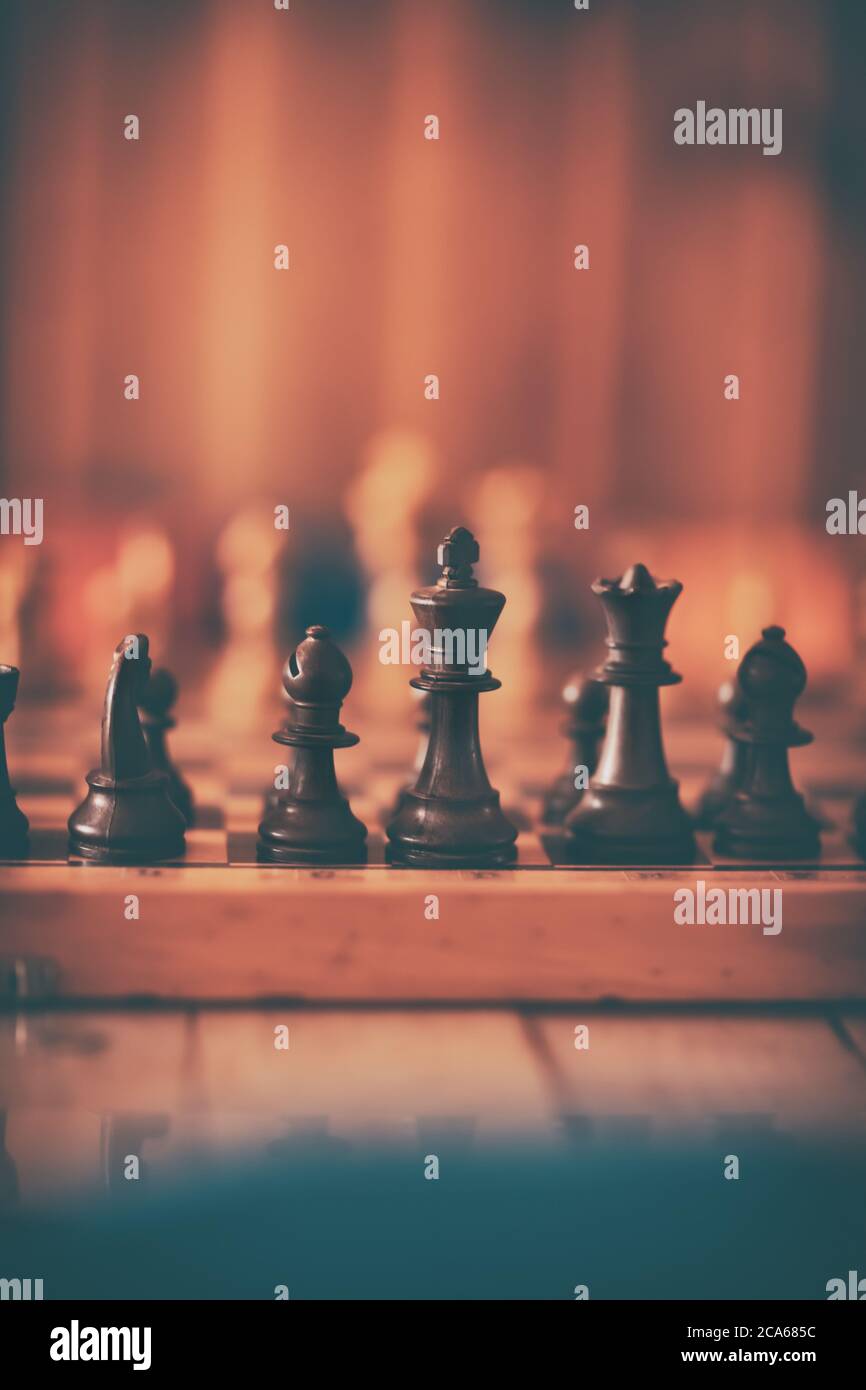 Schachspiel. Schachbrett mit Figuren darauf in Soft Warm Room Light. Intellektueller Sport. Stockfoto