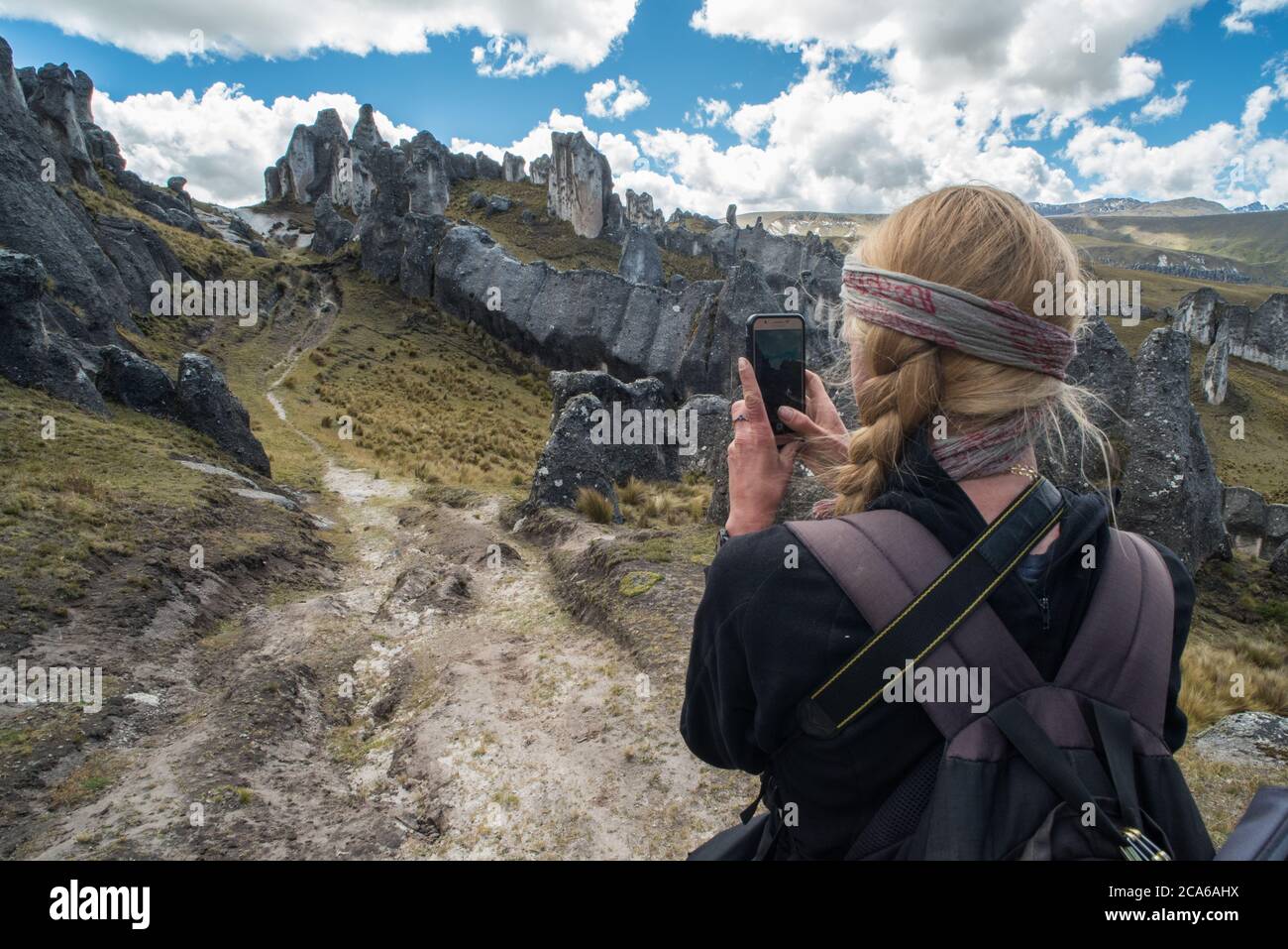 Eine Wanderin in einem Steinwald in einer abgelegenen Region der Anden macht mit ihrem Telefon ein Foto der Landschaft. Stockfoto